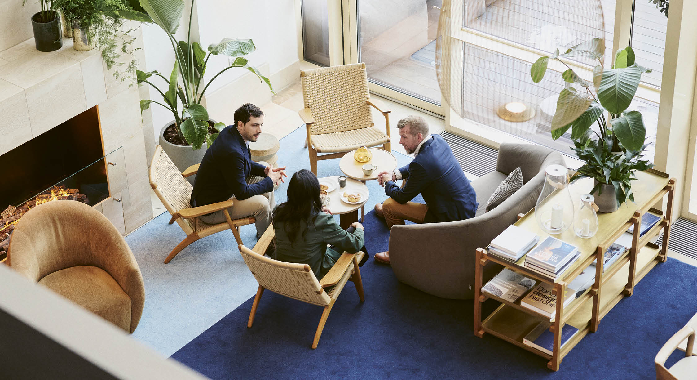 A group of people sitting around a table in a living room. Description generated by AI