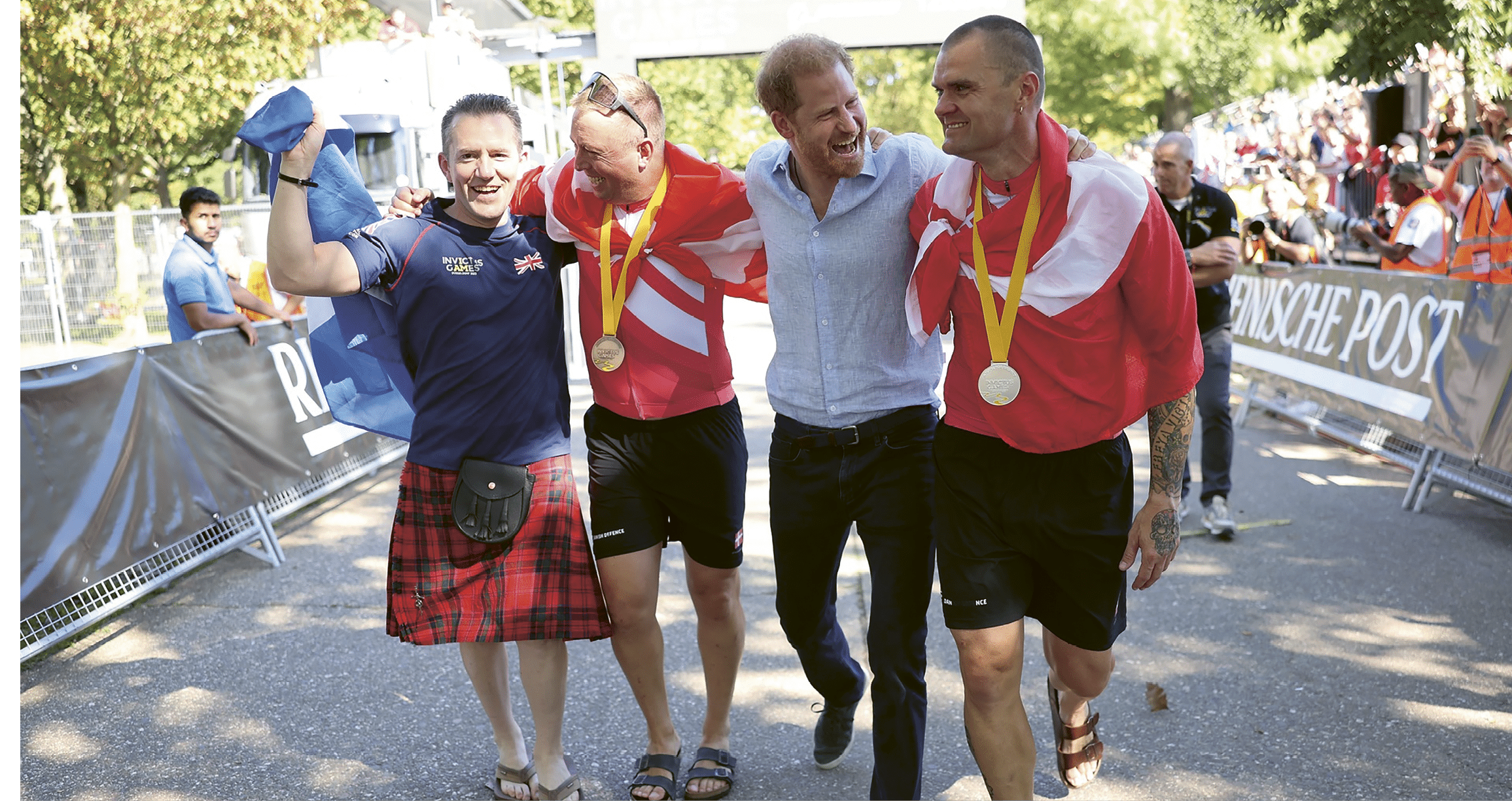 Three men wearing shorts and gold medals. Description generated by AI