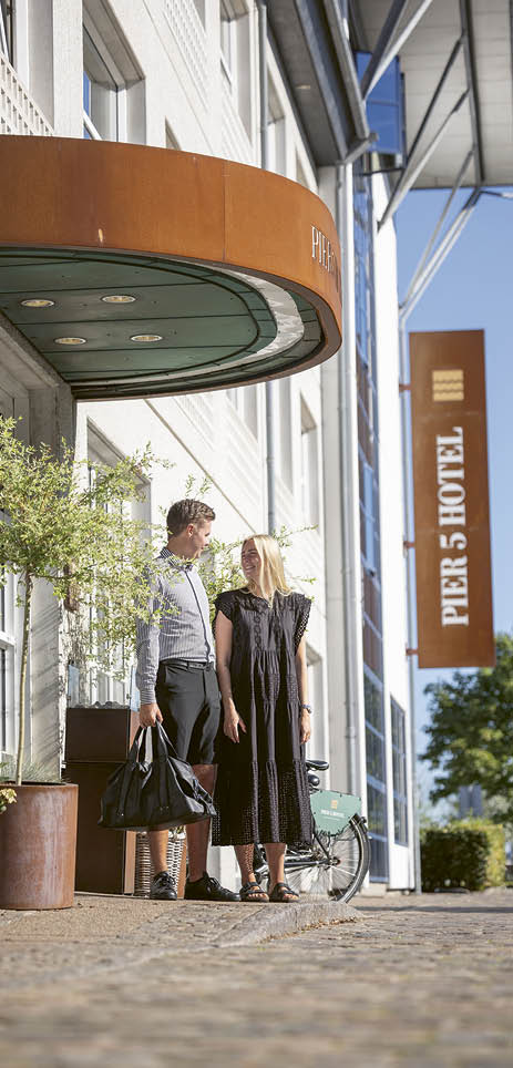 A man and woman standing outside a hotel. Description generated by AI