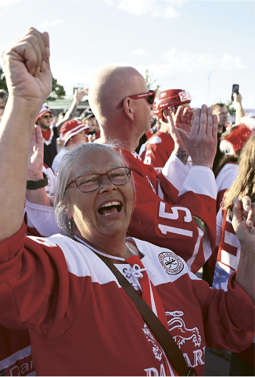 A group of people are wearing red and white jerseys. Description generated by AI