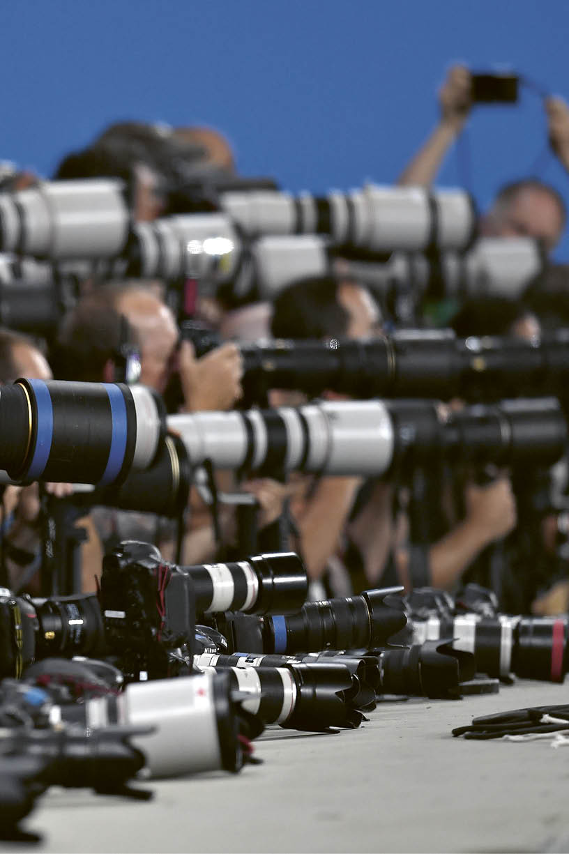 A group of people with cameras and lenses. Description generated by AI