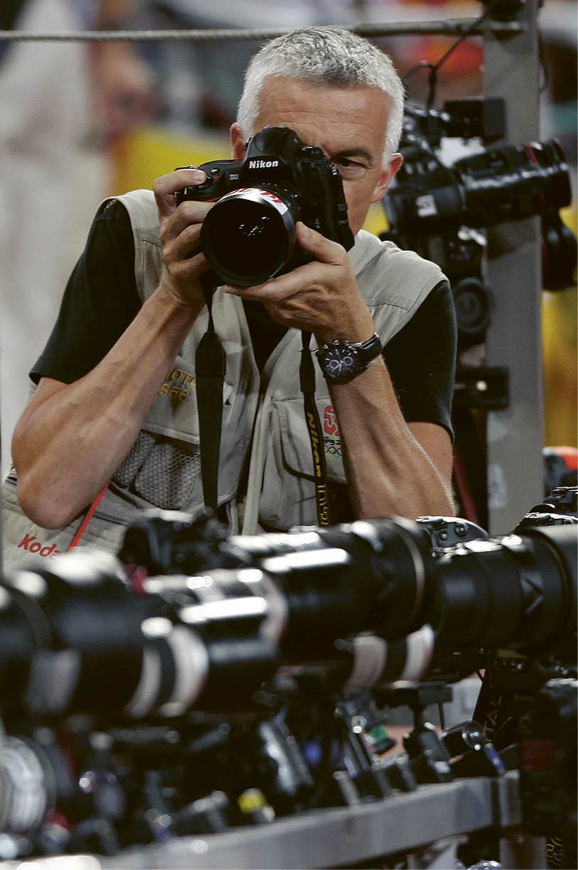 A man is taking a picture of a camera. Description generated by AI