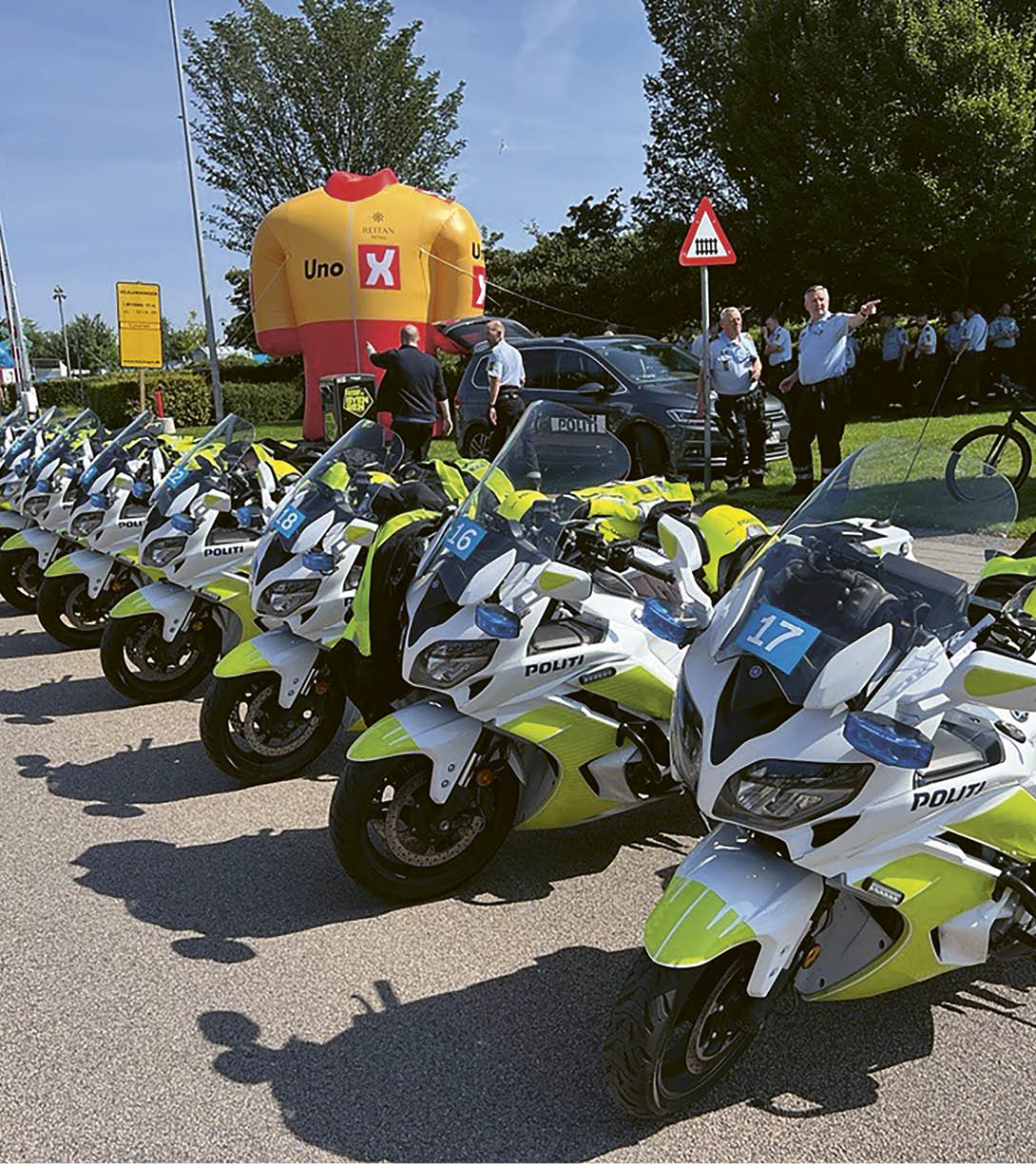 A row of motorcycles parked on the side of the road. Description generated by AI