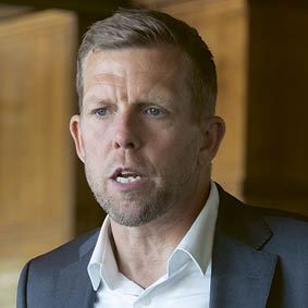 A man wearing a suit and tie. Description generated by AI