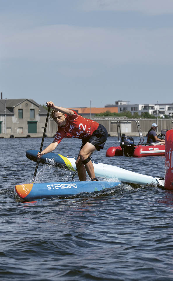 A man is paddling a surfboard in the water. Description generated by AI